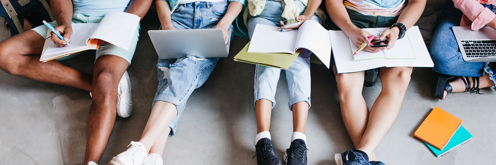 Estudiantes sentados en el piso