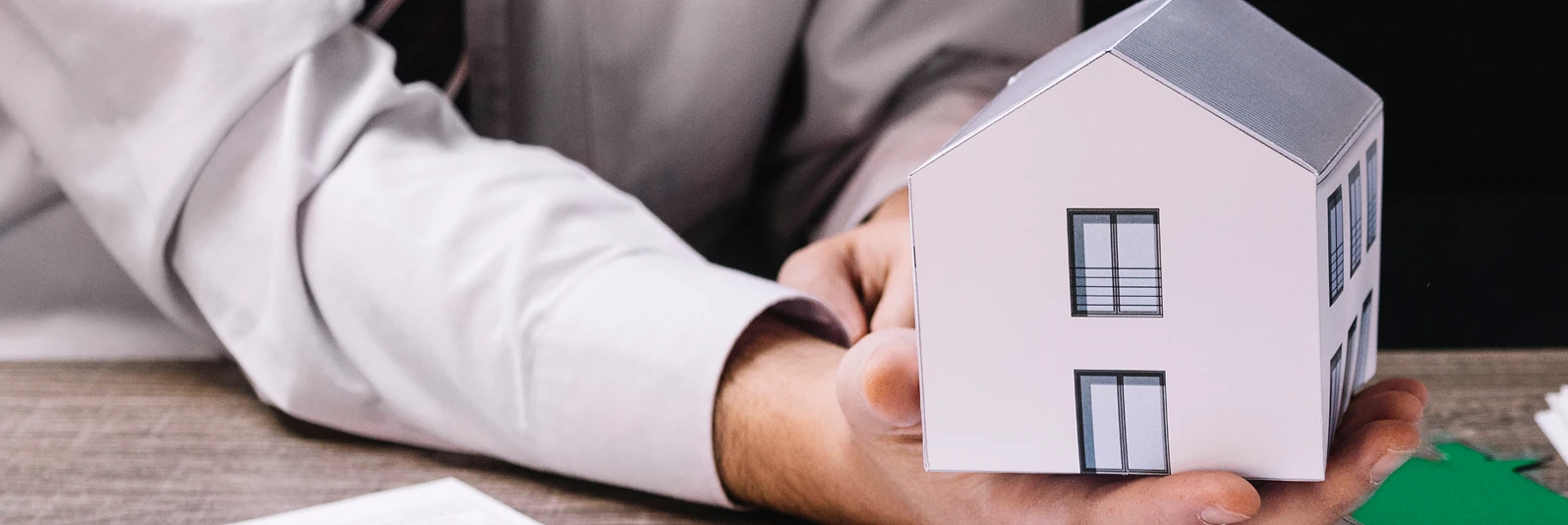 Persona sosteniendo casa en su mano